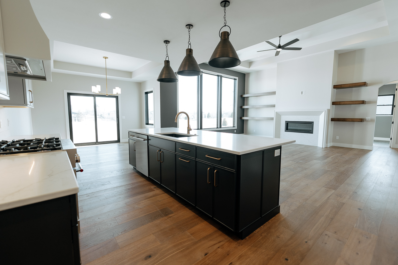 Open-concept kitchen with black island and pendant lighting