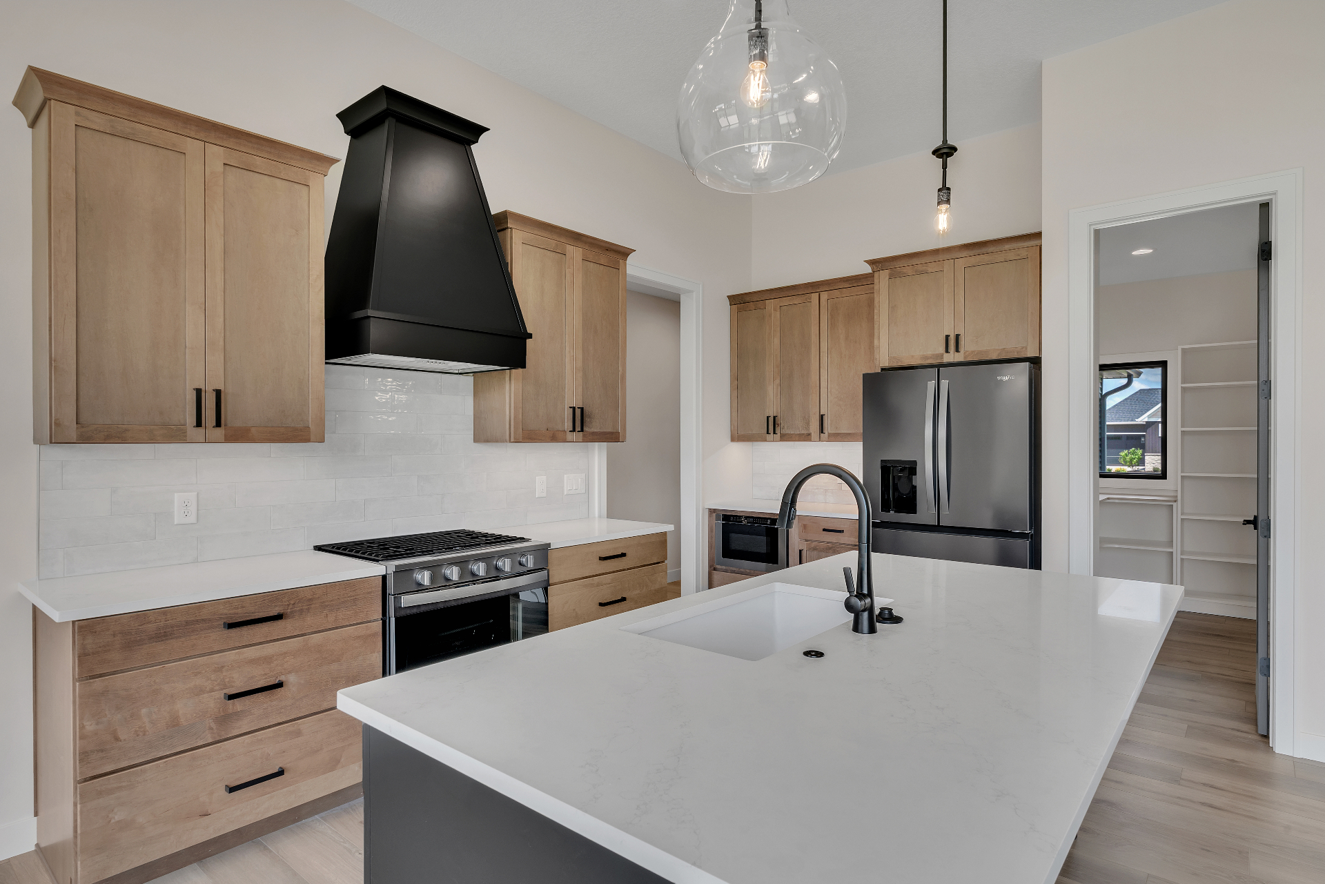 Modern kitchen with black range hood and quartz island